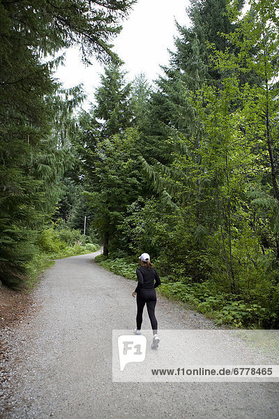 Woman running at Lost Lake trails Whistler  British Columbia