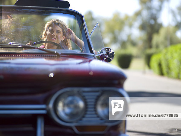 Young woman driving classic's car