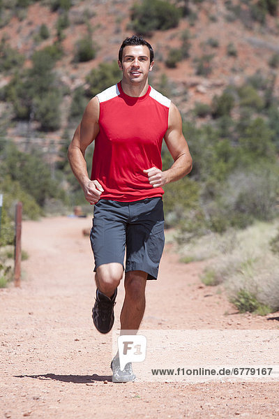 USA  Arizona  Sedona  Young man running in desert