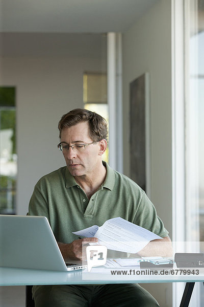Mature man working on laptop at home