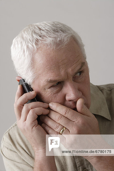Portrait of senior man with mobile phone  studio shot