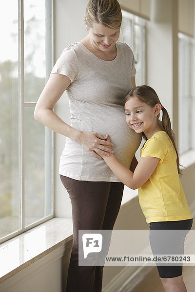 Pregnant woman with daughter (6-7)