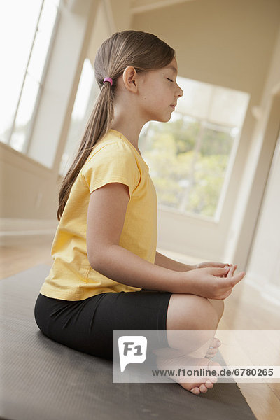 Girl (6-7) practicing yoga