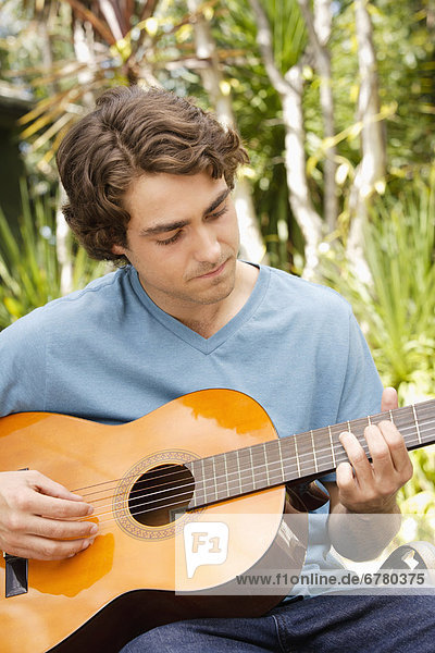 Junger Mann beim Gitarre spielen
