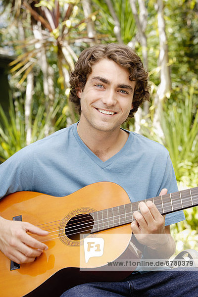 Portrait of young man playing guitar
