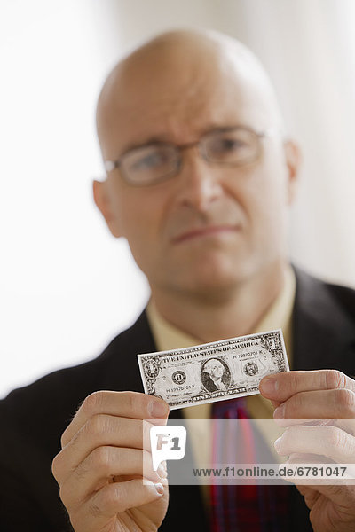Portrait of business man holding one dollar bill