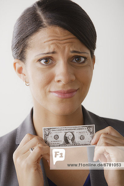 Disappointment businesswoman holding one dollar note  studio shot