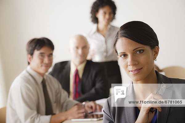 Young businesswoman looking at camera  business team in background
