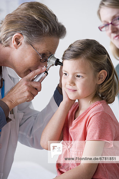 Female doctor examining small girl (4-5)