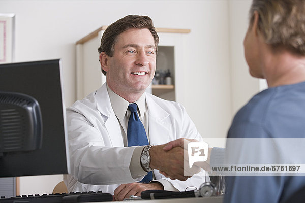 Male doctor shaking hand with patient
