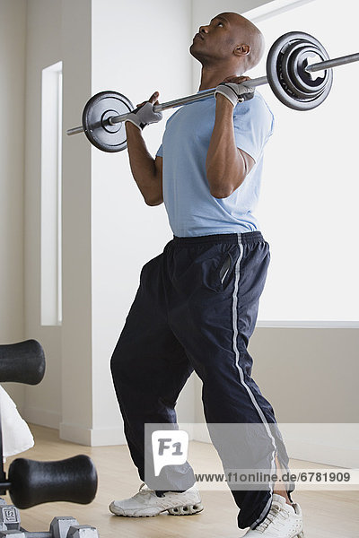 Man lifting barbell in gym