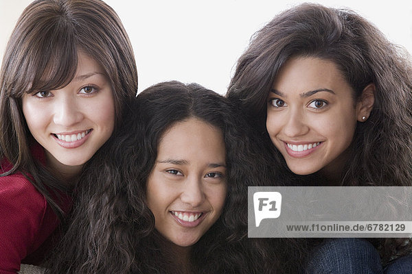 Studio portrait of three young women smiling