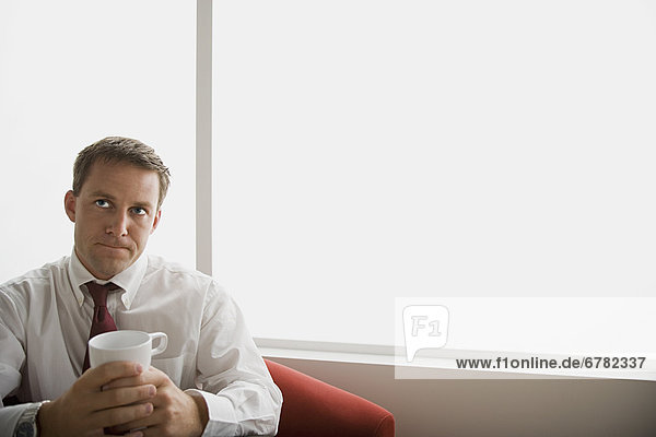 Portrait of businessman sitting with mug