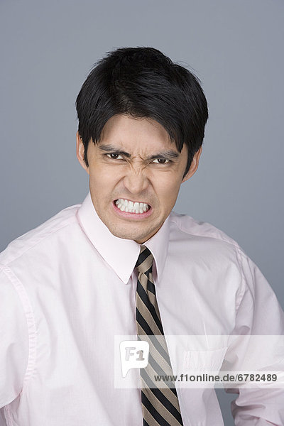 Portrait of young businessman pulling funny faces
