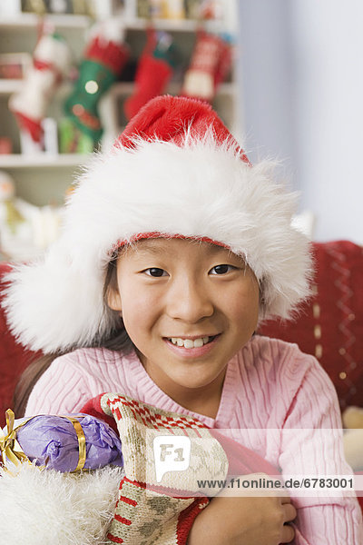Portrait of teenage Girl (10-11) wearing santa hat