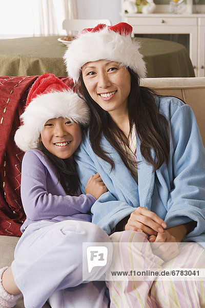 Portrait of mother and daughter wearing Santa hats