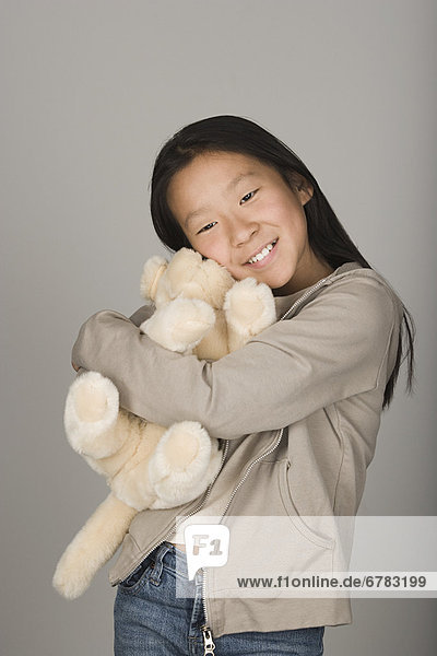 Studio portrait of teen (16-17) hugging stuffed toy