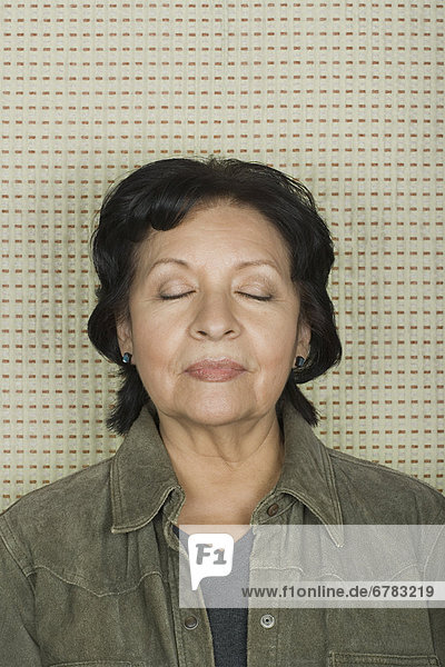 Studio portrait of senior woman with eyes closed
