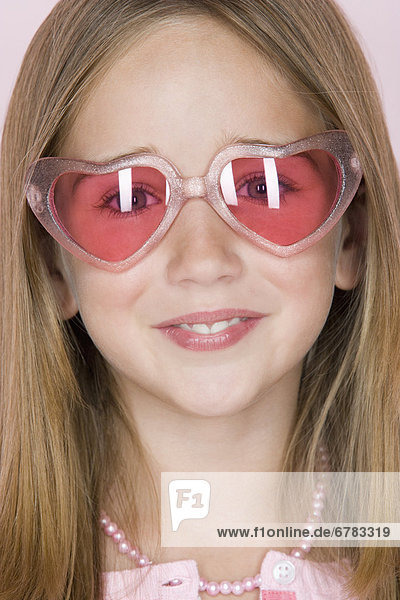 Studio shot portrait of teenage girl in pink sunglasses  close-up