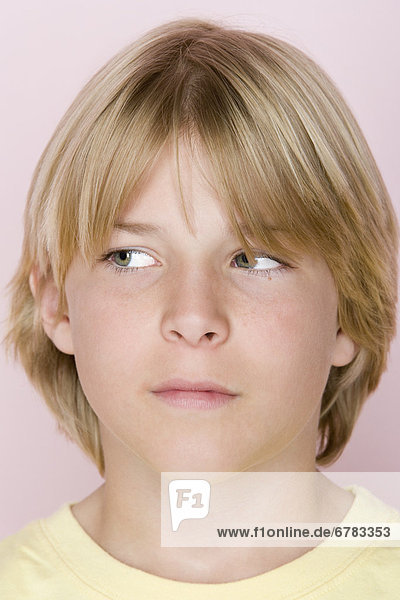 Studio shot portrait of teenage boy looking away  close-up