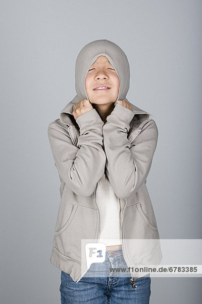 Studio shot portrait of teenage girl in hooded shirt  waist up