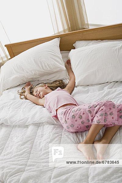 Girl lying in bed in playful pose
