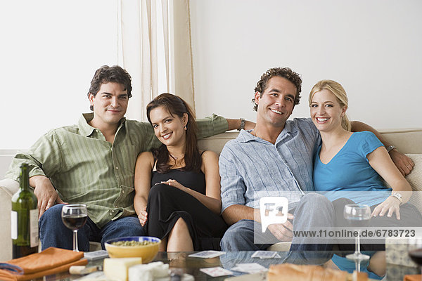 Portrait of two smiling couples sitting on sofa