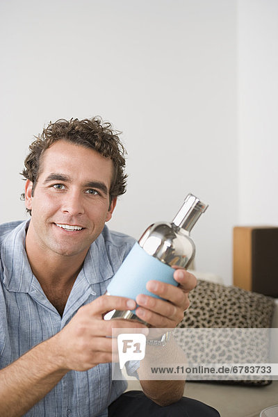 Portrait of smiling man holding cocktail shaker