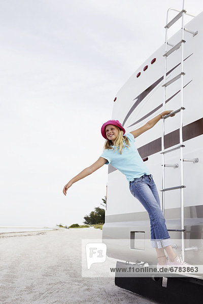 Girl climbing on motor home ladder
