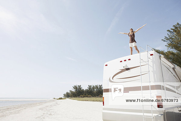 Young woman standing on top of motor home