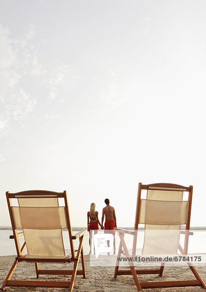 Young couple holding hands on beach