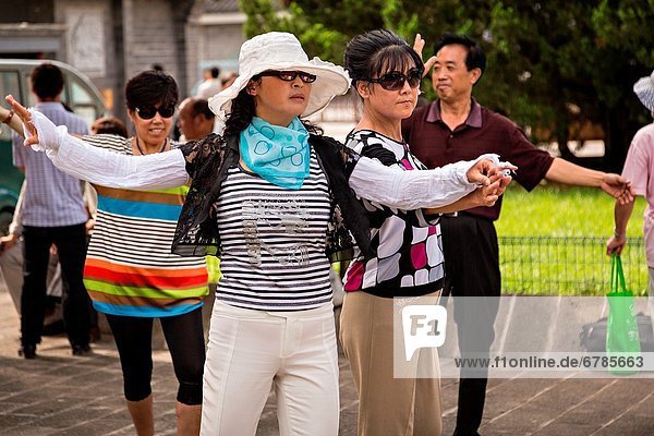 Chinese people dance at the Temple of Heaven Park during summer in Beijing  China