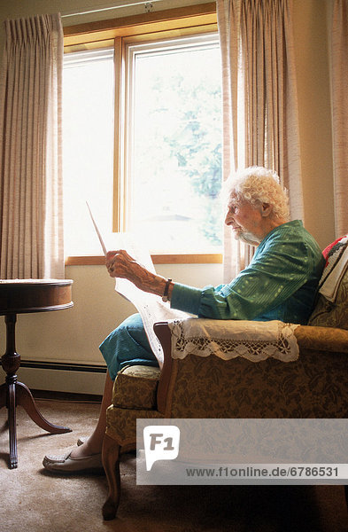 Senior Senioren Frau Fenster Zeitung vorlesen