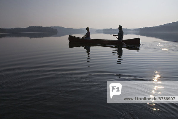 Couple paddling at dawn  Smoke Lake  Algonquin Park  Ontario