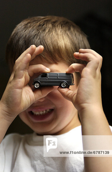 Boy Holding Toy Car in Front of Face