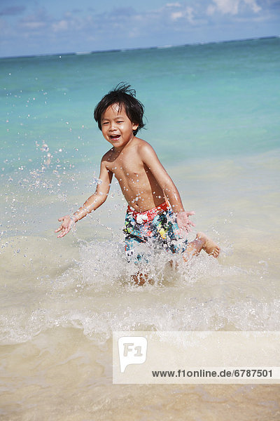 Hawaii  Oahu  Young boy having fun at the beach in the water.