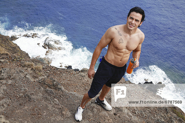 Hawaii  Oahu  Makapuu  sportlichen männlichen hält Wasserflasche taking a Break in Makapuu Cliffs