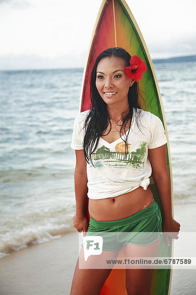 Hawaii  Oahu  schönen lokalen mädchen lächelnd und halten ein colorful Surfbrett am Strand