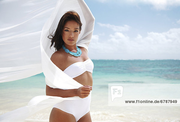 Hawaii  Oahu  Lanikai  Beautiful young woman posing on beach with white fabric blowing in the wind.