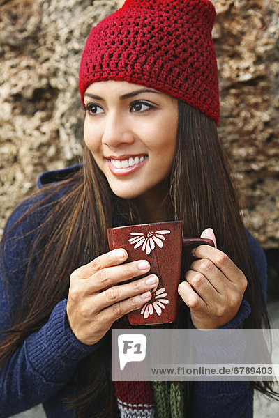 Hawaii  Oahu  junge Frau außerhalb in gemütlichen Winterwetter Kaffee zu trinken.