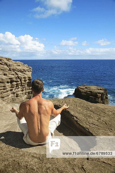 Hawaii  Oahu  Male tun Yoga auf felsigen Klippe.