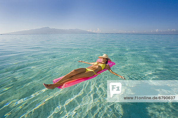 Französisch-Polynesien  Tahiti  Moorea  Frau im Wasser schweben.