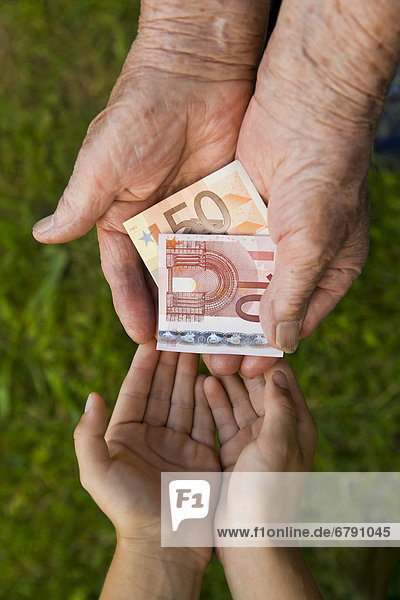 Alte Frau gibt Kind Geld  Euro-Scheine