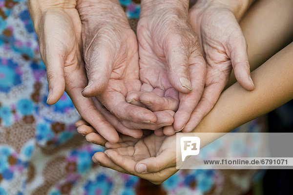 Händer einer erwachsenen und einer alten Frau und eines Kindes