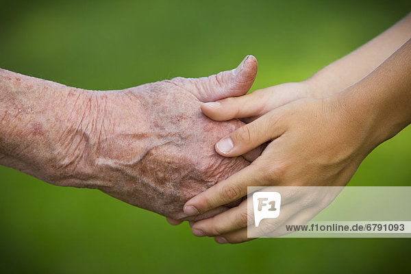 Alte Frau und Kind halten Hände