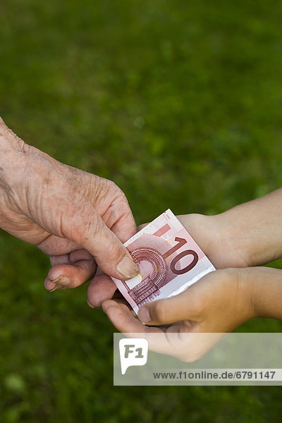 Alte Frau gibt Kind 10-Euro-Schein