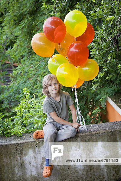 Junge  6 Jahre  mit bunten Luftballons