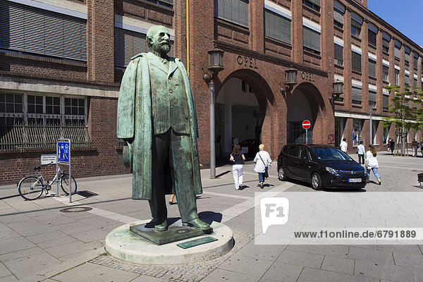 Statue von Adam Opel vor dem alten Portal der Opel Werke Rüsselsheim  Hessen  Deutschland  Europa