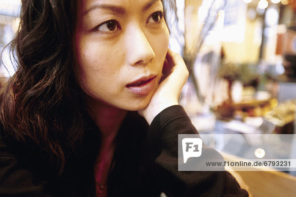 Hong Kong Woman sitting in local cafe Close-up of face rested on hand.