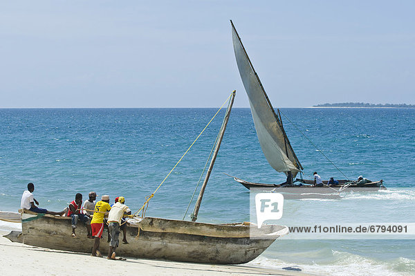 Fishermen and a Ngalawa  a traditional double-outrigger canoe  Zanzibar  Tanzania  Africa